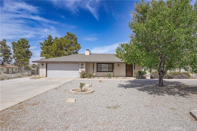15084 Tacony Rd, Apple Valley, CA 92307 - ranch-style house with an attached garage, a chimney, fence, stucco siding, and driveway