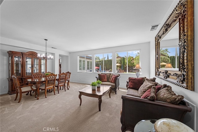living area featuring visible vents, a wealth of natural light, a chandelier, and light carpet
