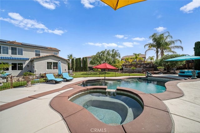view of swimming pool featuring a patio, a pool with connected hot tub, and fence