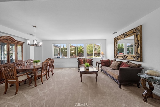 living room featuring visible vents, an inviting chandelier, and light carpet