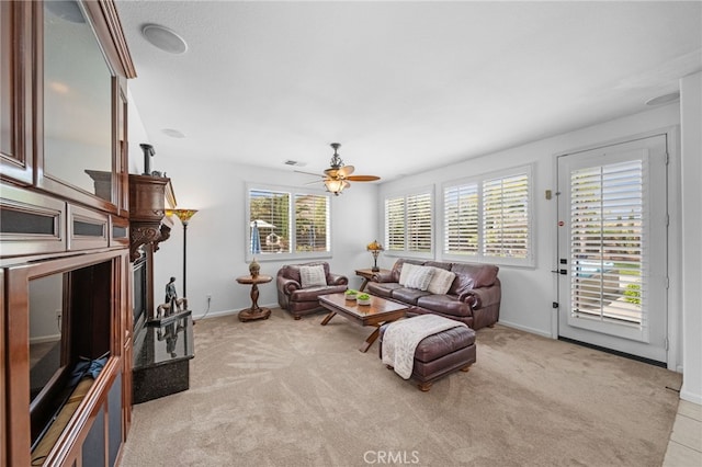 living area with light carpet, ceiling fan, baseboards, and visible vents