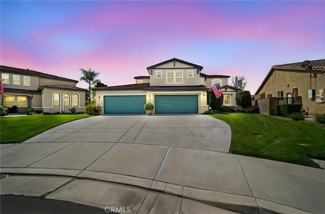 view of front of house with driveway, stucco siding, a garage, and a lawn