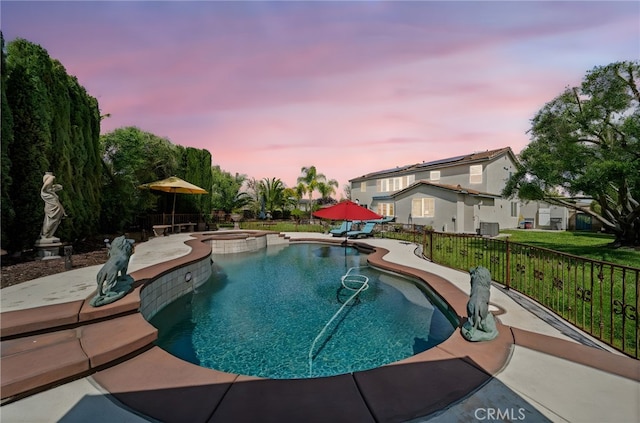 view of swimming pool with a patio, a pool with connected hot tub, and fence