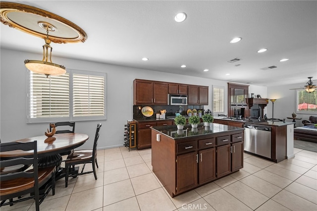 kitchen with a ceiling fan, recessed lighting, a kitchen island, appliances with stainless steel finishes, and light tile patterned flooring