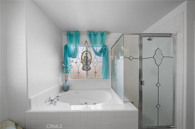 bathroom with a shower stall and a jetted tub