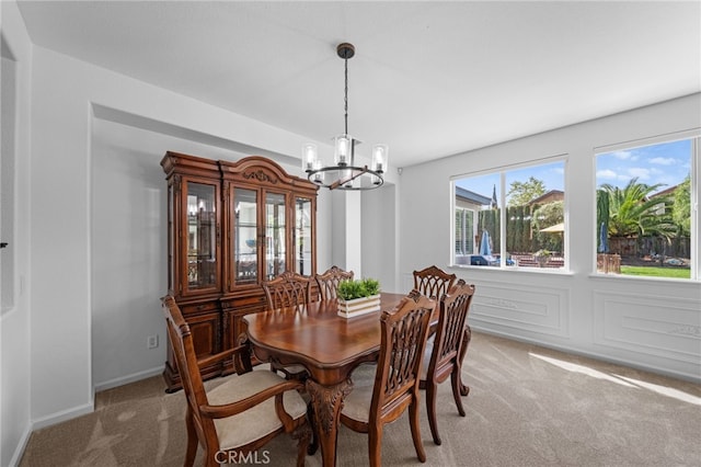 dining area with light colored carpet and an inviting chandelier