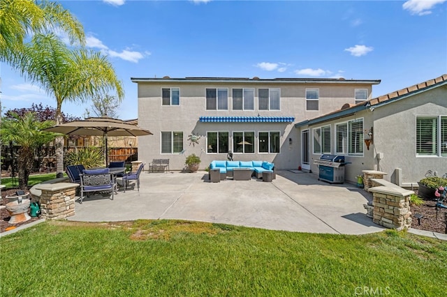 rear view of property featuring an outdoor hangout area, stucco siding, a lawn, a patio, and fence