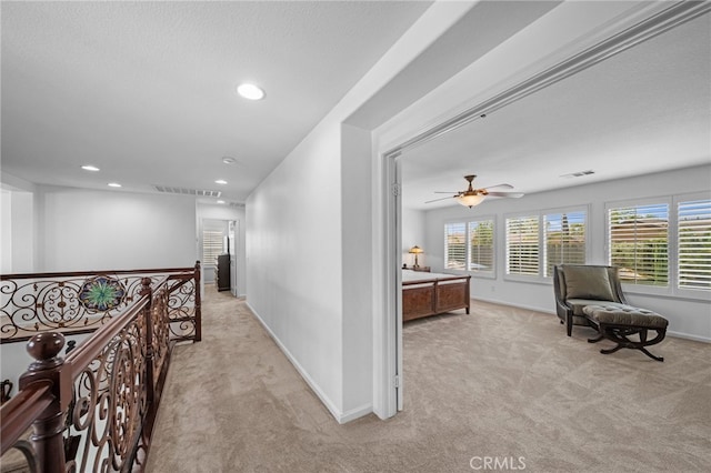 corridor with light carpet, recessed lighting, an upstairs landing, and baseboards