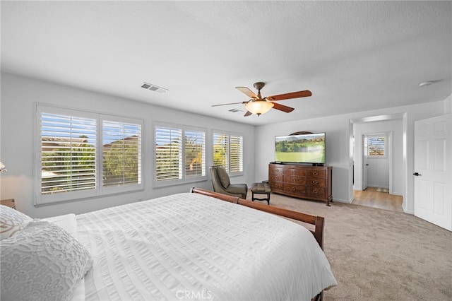 bedroom with light carpet, visible vents, and ceiling fan