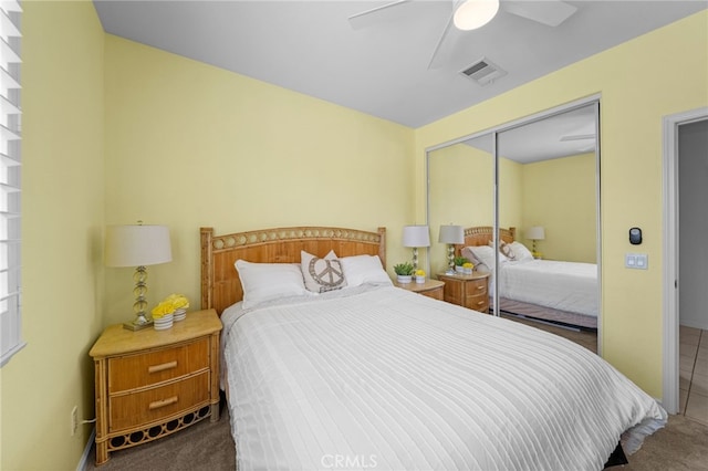carpeted bedroom featuring a closet, ceiling fan, and visible vents
