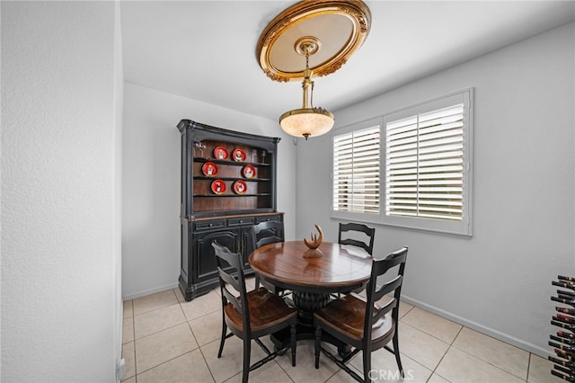 dining space featuring light tile patterned floors and baseboards