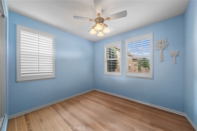 unfurnished room with baseboards, ceiling fan, and wood finished floors