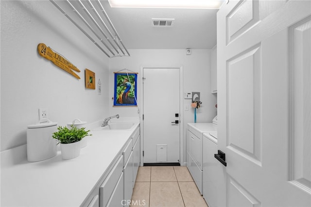 clothes washing area featuring cabinet space, visible vents, light tile patterned flooring, a sink, and washing machine and dryer