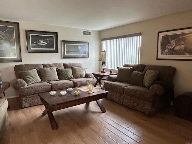 living area featuring visible vents and wood finished floors