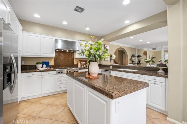 115 Vermillion, Irvine, CA 92603 - kitchen featuring white cabinets, a center island, wall chimney exhaust hood, stainless steel appliances, and light tile patterned flooring