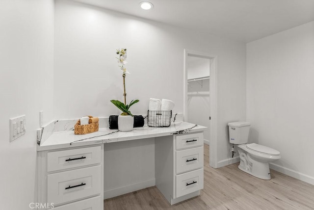 bathroom with vanity, recessed lighting, toilet, wood finished floors, and baseboards