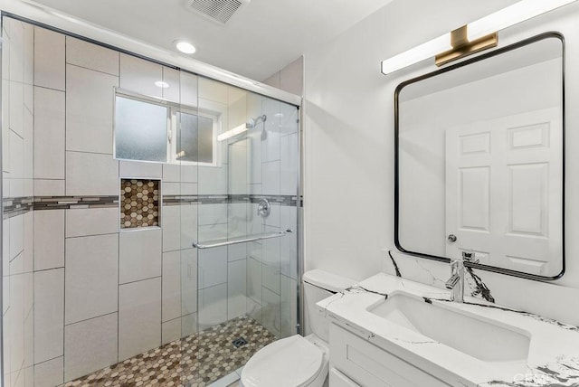 bathroom with visible vents, toilet, a shower stall, recessed lighting, and vanity