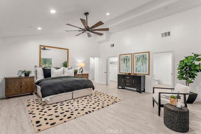 bedroom with visible vents, high vaulted ceiling, and wood finished floors