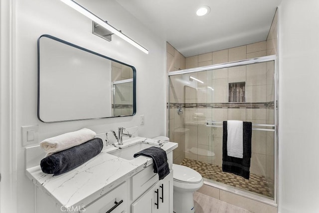 full bathroom featuring toilet, a stall shower, vanity, and recessed lighting