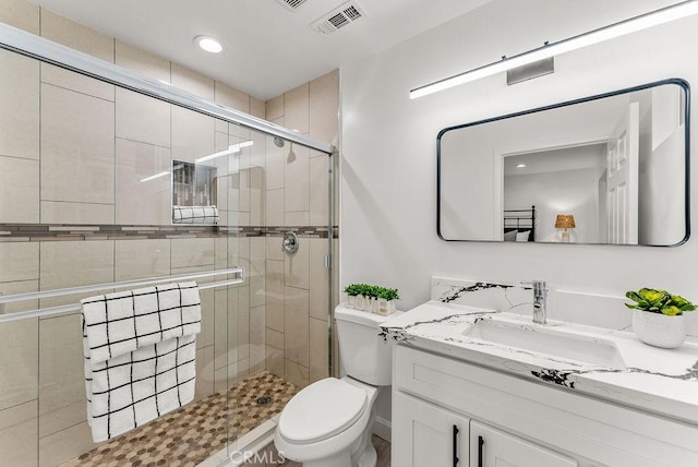 full bathroom featuring a shower stall, vanity, visible vents, and toilet
