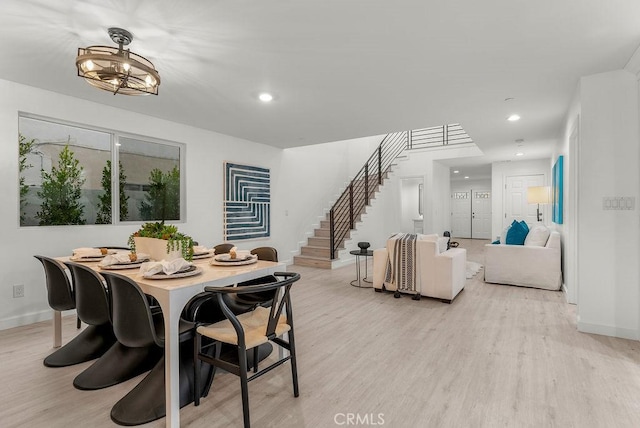dining room featuring light wood finished floors, baseboards, recessed lighting, and stairway