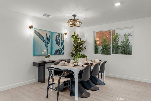 dining area featuring visible vents, baseboards, and wood finished floors