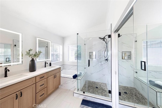 full bathroom with a garden tub, lofted ceiling, a sink, and a marble finish shower