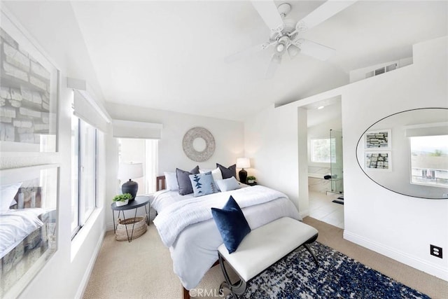 bedroom featuring lofted ceiling, visible vents, carpet floors, baseboards, and ensuite bathroom
