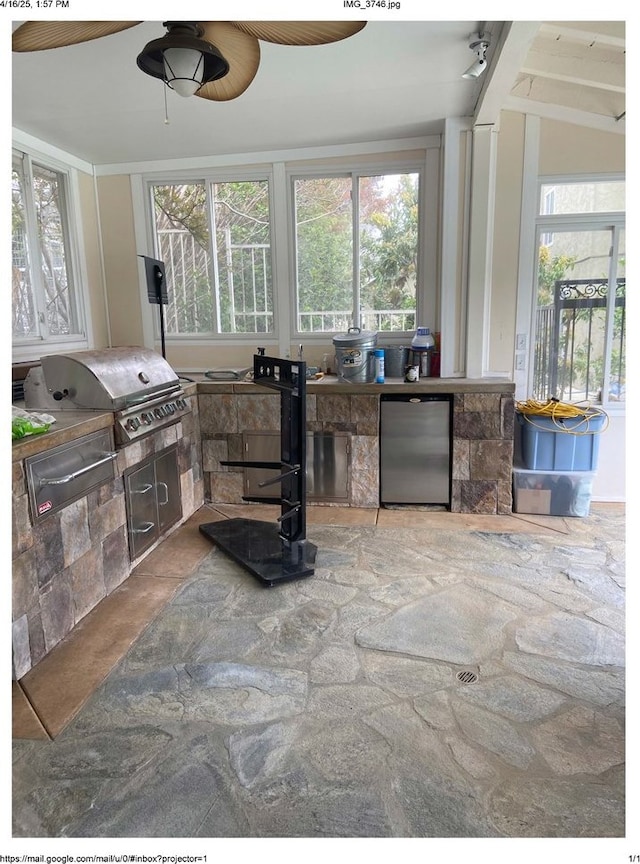 interior space featuring stone finish flooring, refrigerator, and a ceiling fan