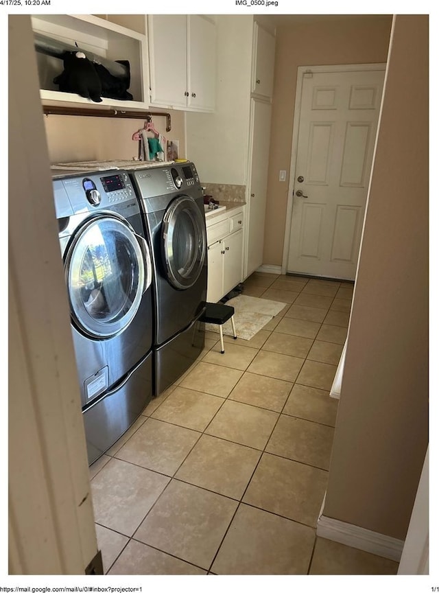laundry room with light tile patterned flooring, washer and dryer, and cabinet space
