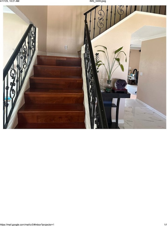 stairway with marble finish floor and baseboards