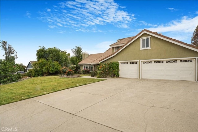 traditional home with concrete driveway, a tile roof, a front yard, an attached garage, and stucco siding