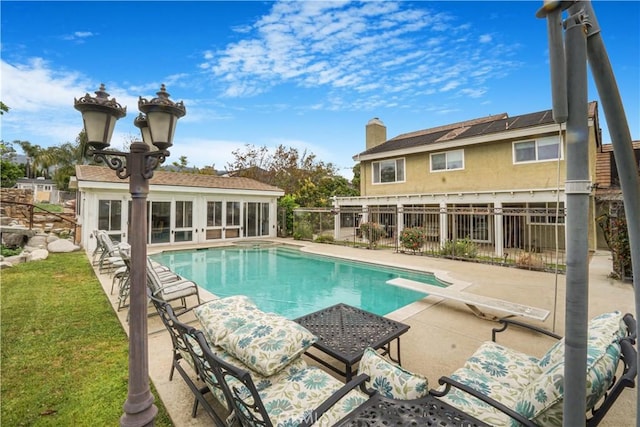view of swimming pool with fence, a diving board, a patio area, and a fenced in pool