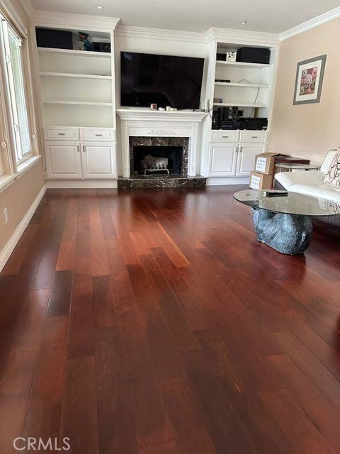 living area with ornamental molding, dark wood-style flooring, and a fireplace
