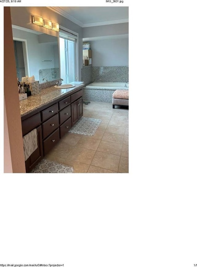 bathroom with tile patterned floors, a garden tub, vanity, and ornamental molding