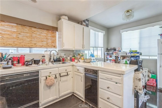 18641 Nathan Hill Dr Unit 8, Canyon Country, CA 91351 - kitchen featuring tile counters, white cabinetry, black dishwasher, and a peninsula