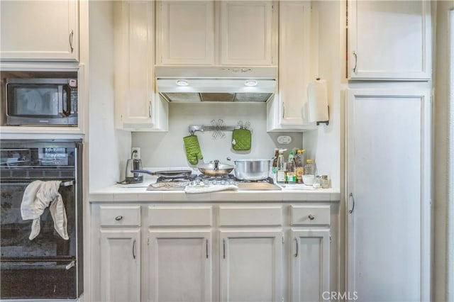 18641 Nathan Hill Dr Unit 8, Canyon Country, CA 91351 - kitchen featuring white cabinets, oven, under cabinet range hood, tile counters, and stainless steel gas cooktop