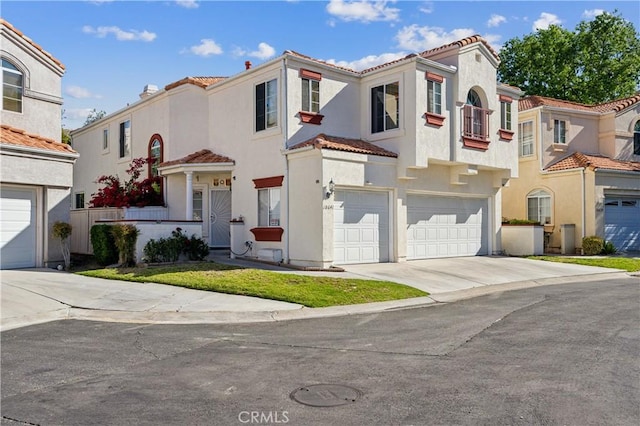 18641 Nathan Hill Dr Unit 8, Canyon Country, CA 91351 - mediterranean / spanish-style house featuring concrete driveway, stucco siding, a tiled roof, and a garage