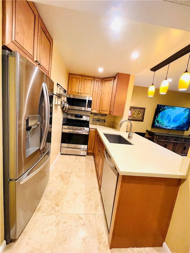 kitchen featuring a peninsula, light countertops, brown cabinetry, stainless steel appliances, and a sink