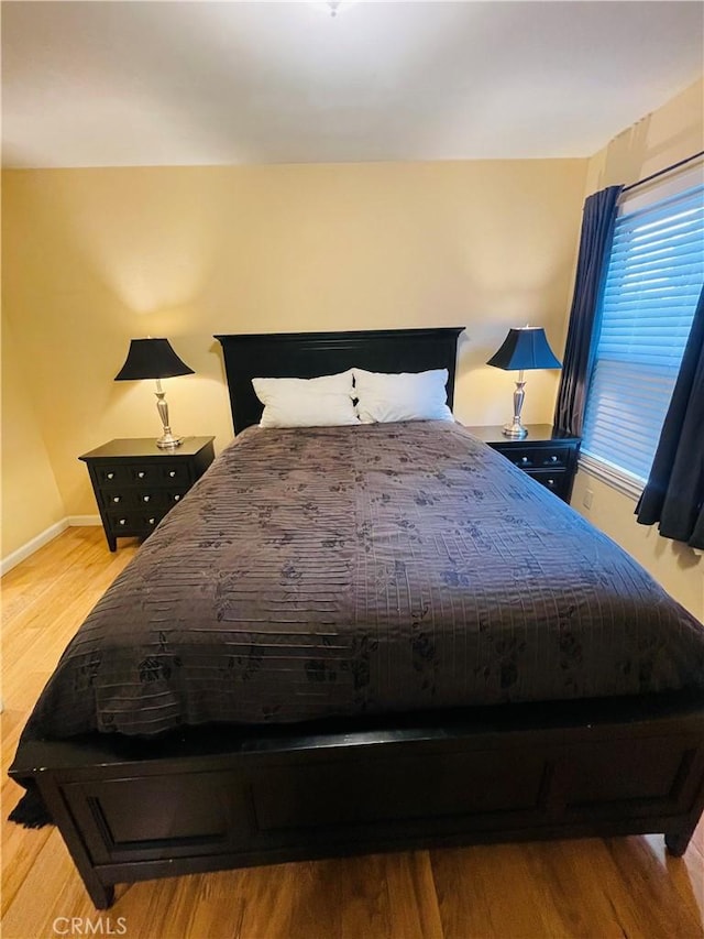 bedroom with baseboards and wood finished floors