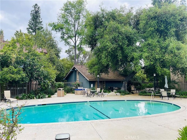 pool with fence and a patio