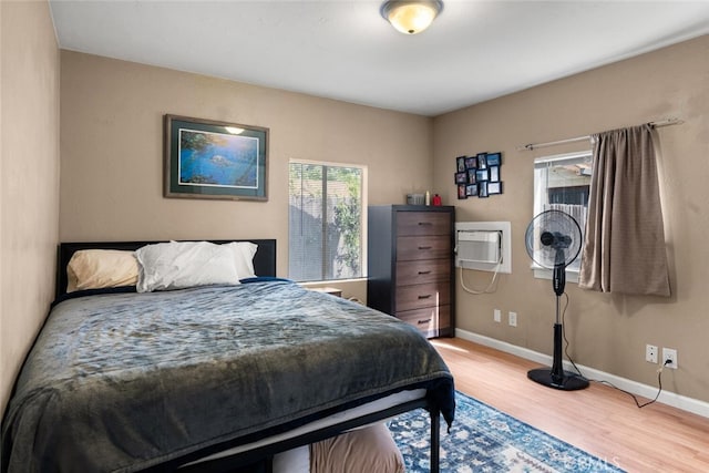 1109 Ivy St, Chico, CA 95928 - bedroom featuring wood finished floors, a wall unit AC, and baseboards