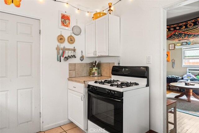 1109 Ivy St, Chico, CA 95928 - kitchen with gas stove, light countertops, and white cabinetry
