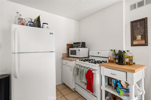 1109 Ivy St, Chico, CA 95928 - kitchen featuring light tile patterned floors, white appliances, butcher block counters, white cabinetry, and visible vents