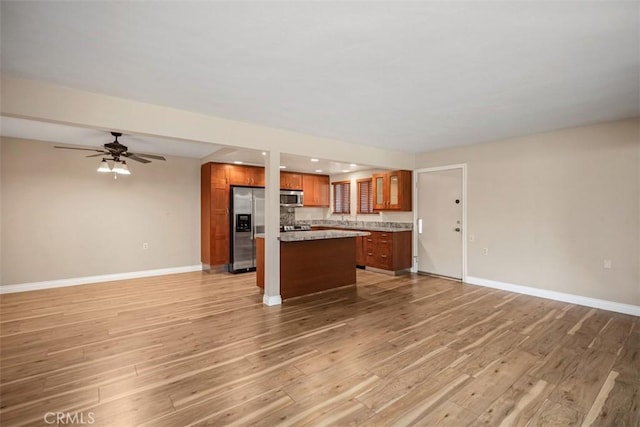 659 Avenida Sevilla Unit D, Laguna Woods, CA 92637 - kitchen with brown cabinetry, stainless steel appliances, light wood-type flooring, and open floor plan