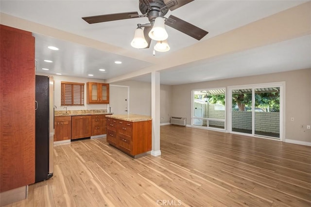 659 Avenida Sevilla Unit D, Laguna Woods, CA 92637 - kitchen featuring brown cabinetry, light wood-style flooring, freestanding refrigerator, open floor plan, and paneled dishwasher