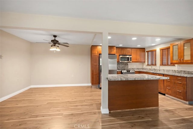659 Avenida Sevilla Unit D, Laguna Woods, CA 92637 - kitchen with brown cabinetry, light wood-style floors, baseboards, recessed lighting, and stainless steel appliances