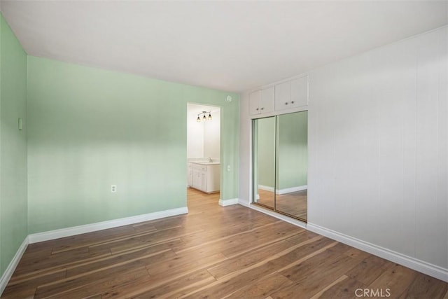 659 Avenida Sevilla Unit D, Laguna Woods, CA 92637 - unfurnished bedroom featuring a sink, baseboards, a closet, and wood finished floors