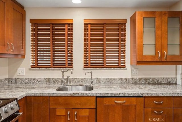 659 Avenida Sevilla Unit D, Laguna Woods, CA 92637 - kitchen with a sink, brown cabinets, electric stove, and light countertops