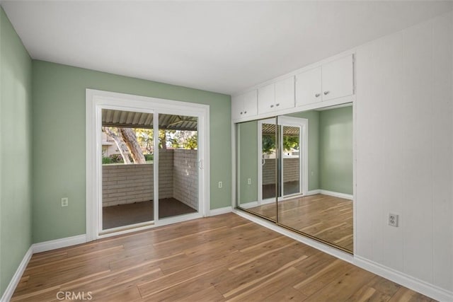 659 Avenida Sevilla Unit D, Laguna Woods, CA 92637 - unfurnished bedroom featuring baseboards, light wood finished floors, and access to exterior